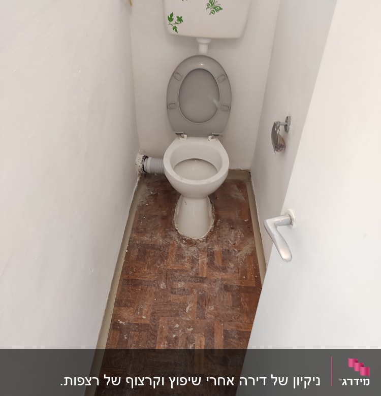 אסלה עם מכסה פתוח בחדר שירותים קטן
